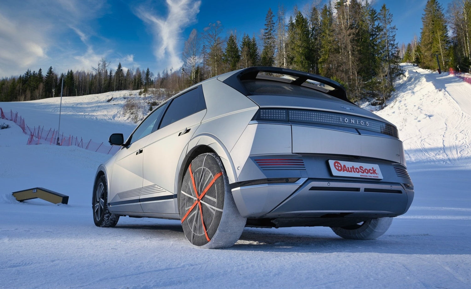 AutoSock monté sur les roues arrière d'une voiture, debout sur la neige en hiver